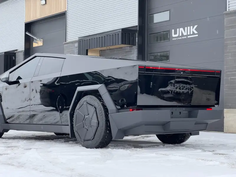 Tesla Cybertruck avec panneaux noir lustré devant l’atelier UNIK