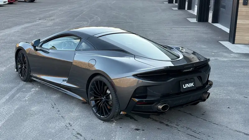 McLaren GT gris foncé devant l’atelier UNIK