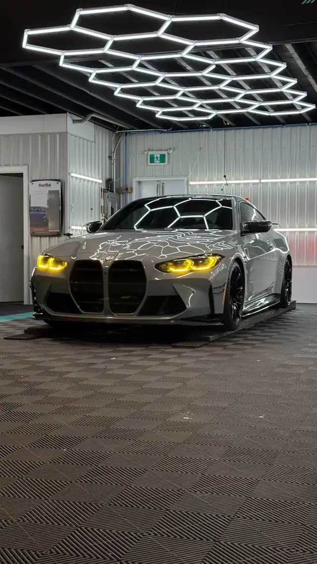 BMW M4 grise aux vitres teintées dans l’atelier UNIK